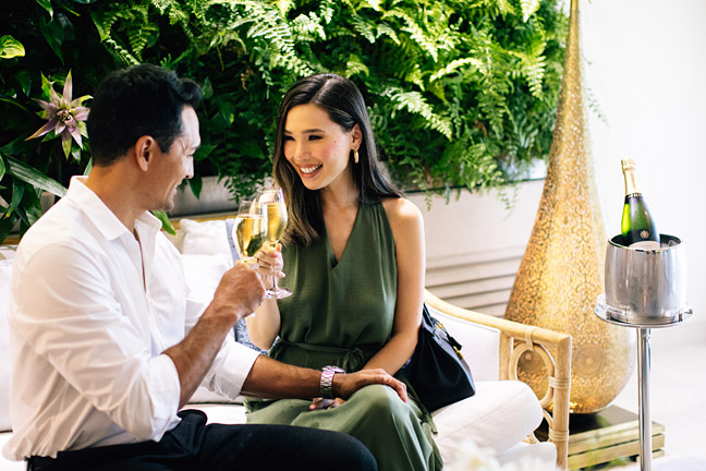 Couple enjoying welcome wine in reception area.
