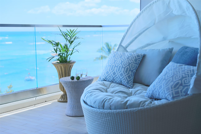 Balcony lounge furniture and view of ocean.
