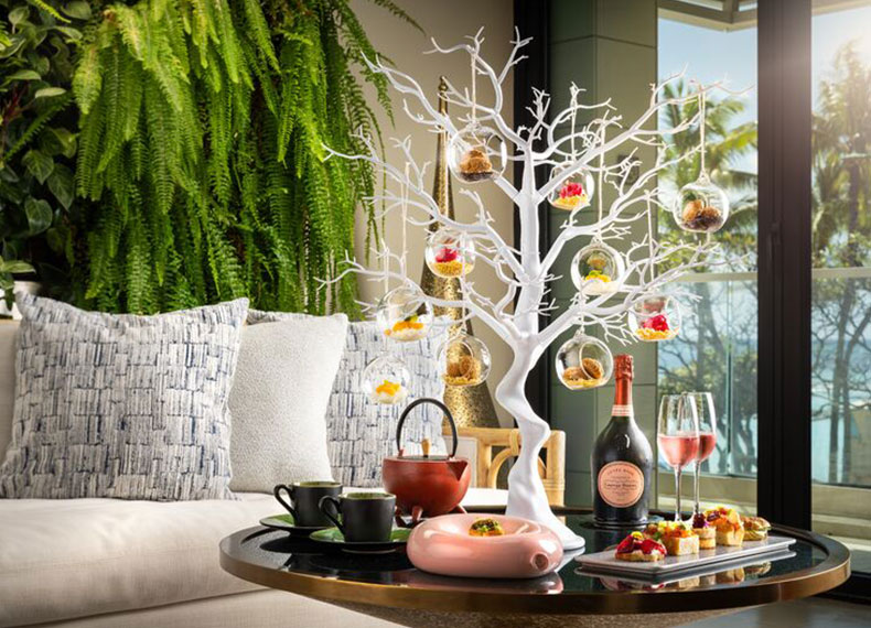 Ornaments on decorative tree and tea service spread.