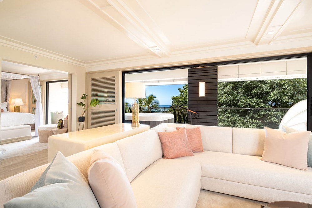 Living area, couch, furnished balcony with Jacuzzi and ocean views.