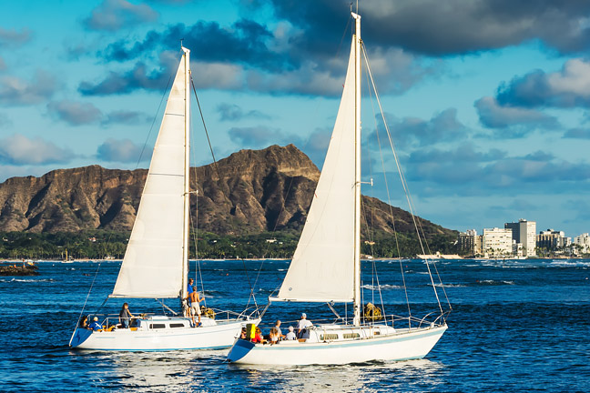 Sailboats on the Pacific Ocean with Diamond Head in the background.