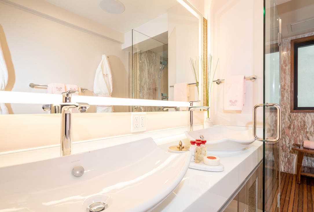 Bathroom with 2 sinks, premium toiletries, and marble shower.