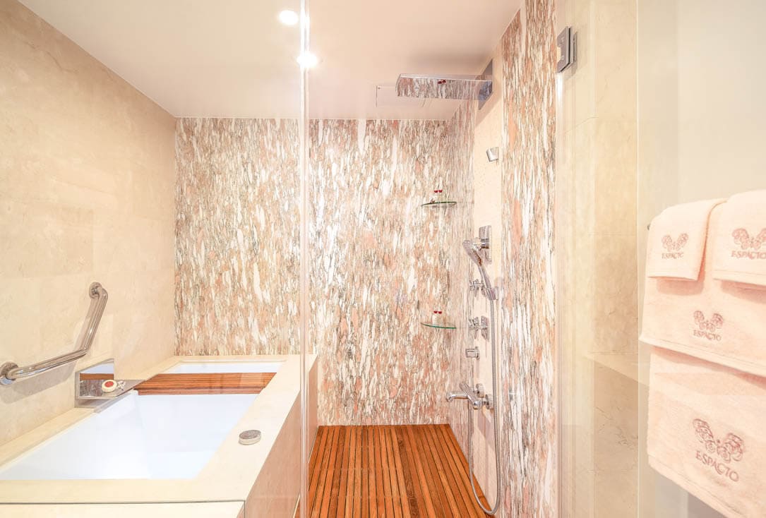 Marble bathroom with tub and separate shower.